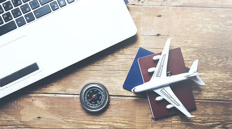 Travel objects and keyboard on the table background